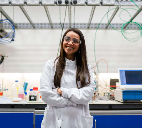 Female chemical engineer in laboratory develops clean energy storage solutions.