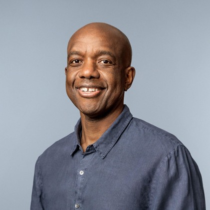 Head and shoulders photo of a man, smiling at camera