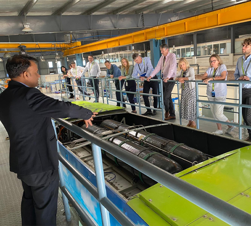 Person in front of a machine talking to a group of people