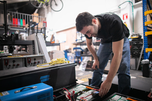 Photo of Alejandro looking at a recycled battery.