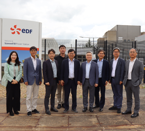 Group photo of delegates standing in front of an EDF Sizewell B Power Station sign