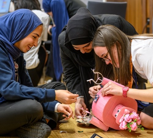 A group of girls working on their robot