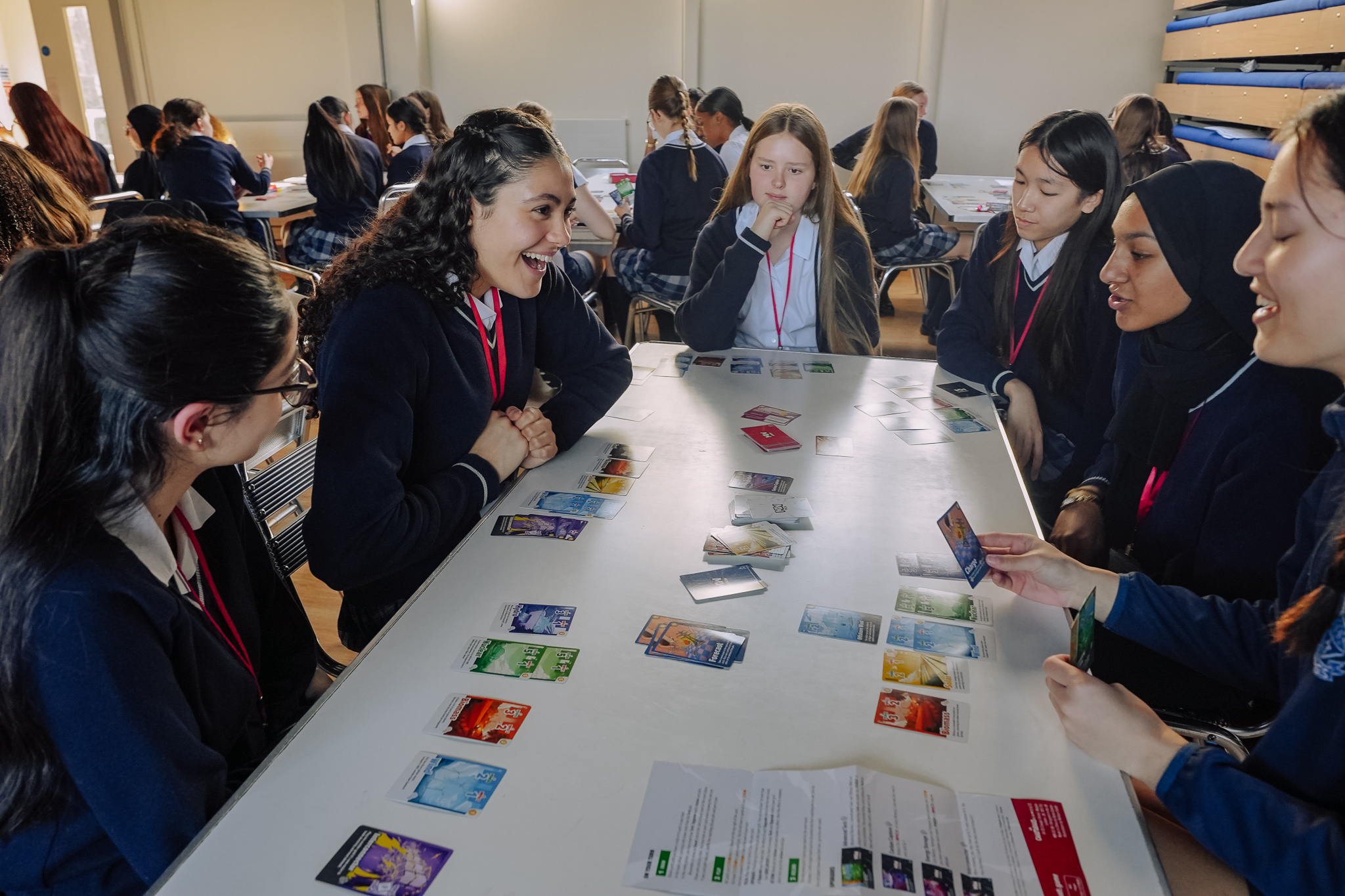 A group of students sitting at a table playing the card game