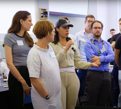 Participant speaking into a microphone during a group discussion at an event.