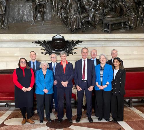 Group of people standing for a formal photo inside a historic building.