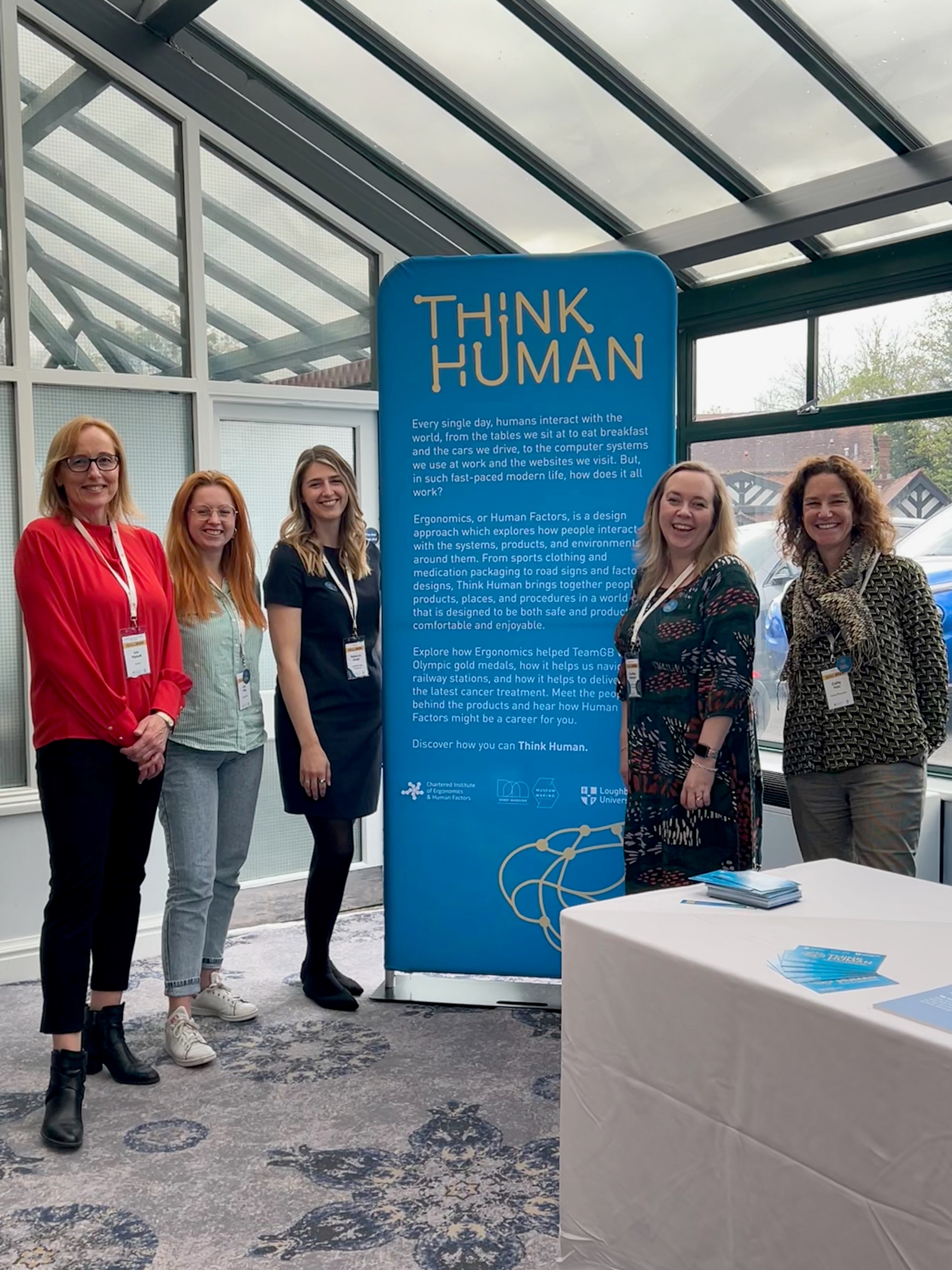 Picture showing team in front of Think Human roller banner