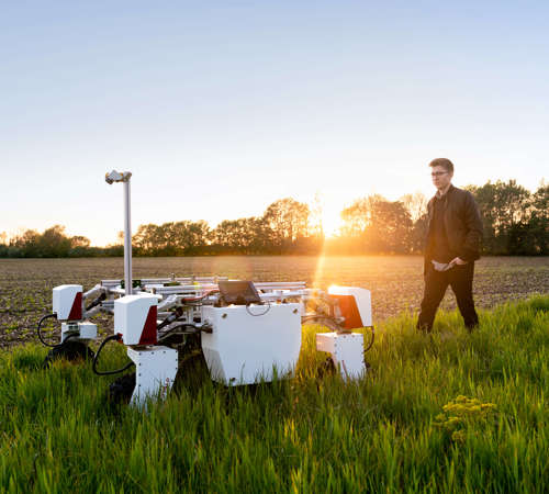 Engineer walking by an agricultural device.
