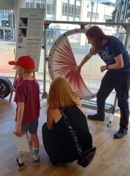 A team member showing a parent and their child one of the exhibitions