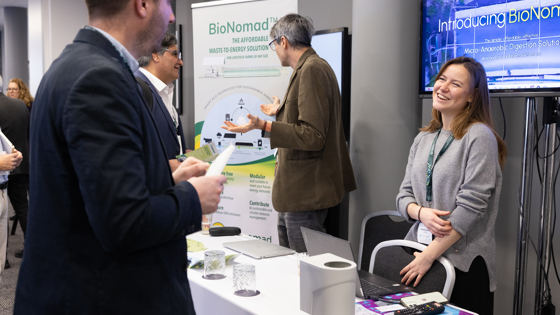 Conference attendees talking at an exhibition stand