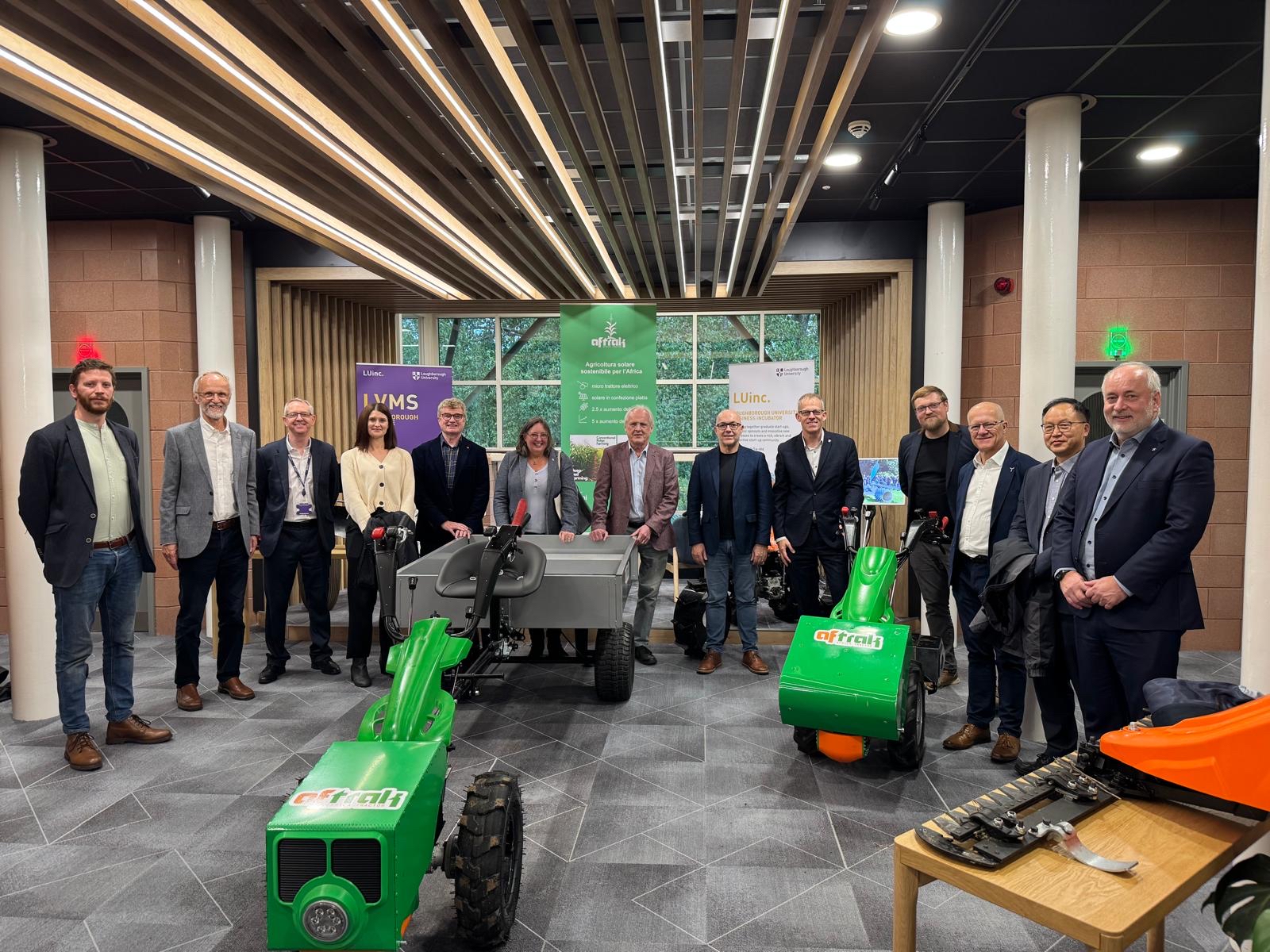 Researchers and industry partners with several large pieces of agricultural technology.