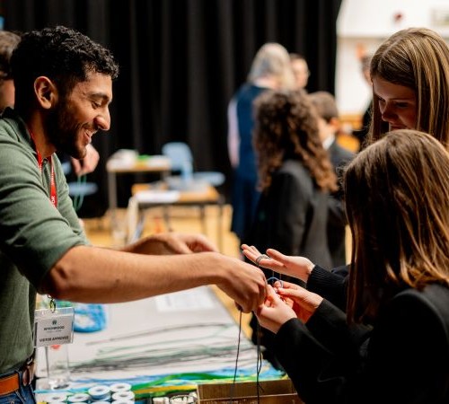 Two students interacting with one of the team